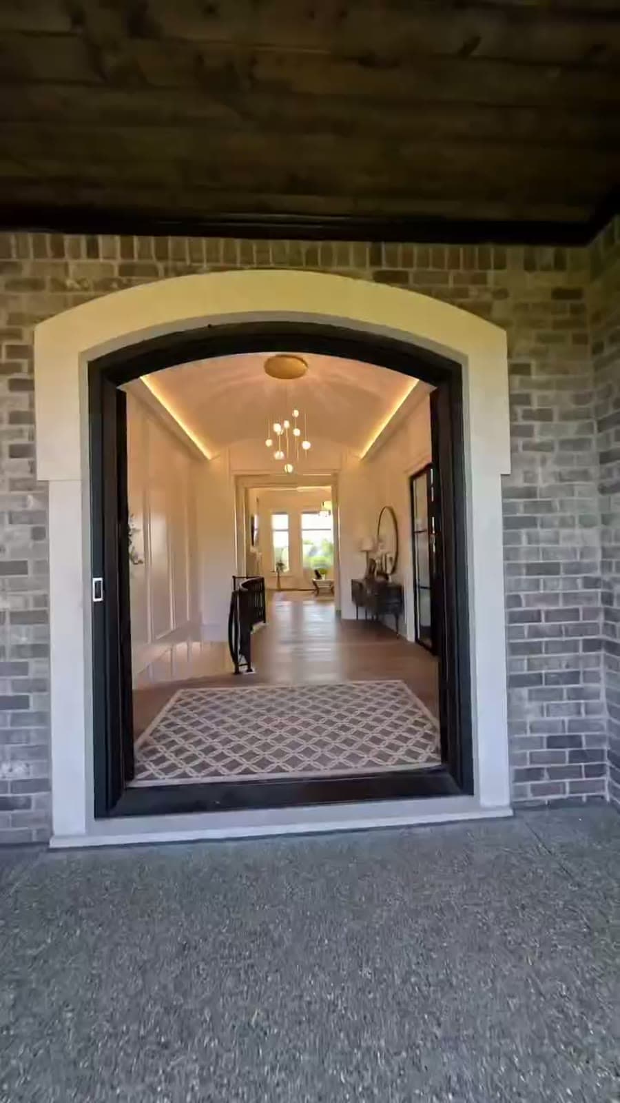 Arched brick entryway opening onto a lit hallway